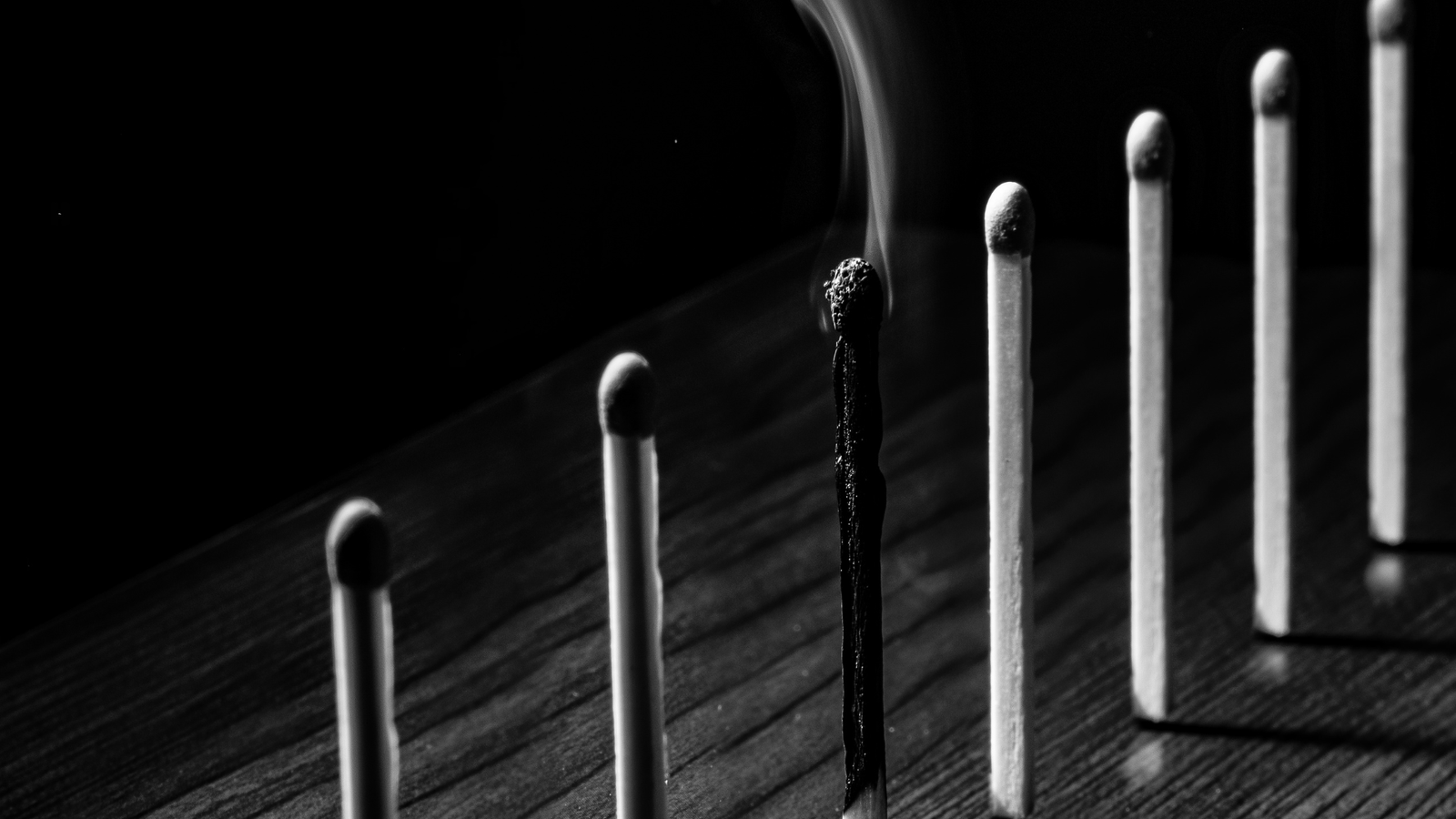 burnout-7-alertas-ignorados-profissionais-experientes.jpg Sete palitos de fósforo alinhados, simbolizando o desgaste silencioso de profissionais no home office, Burnout