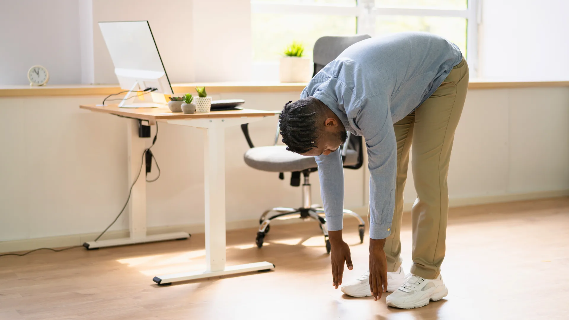 Home office sem dor: 5 alongamentos para aliviar dores e tensões em minutos 1 Homem se alongando durante o home office para aliviar dores musculares e melhorar a postura alongamentos