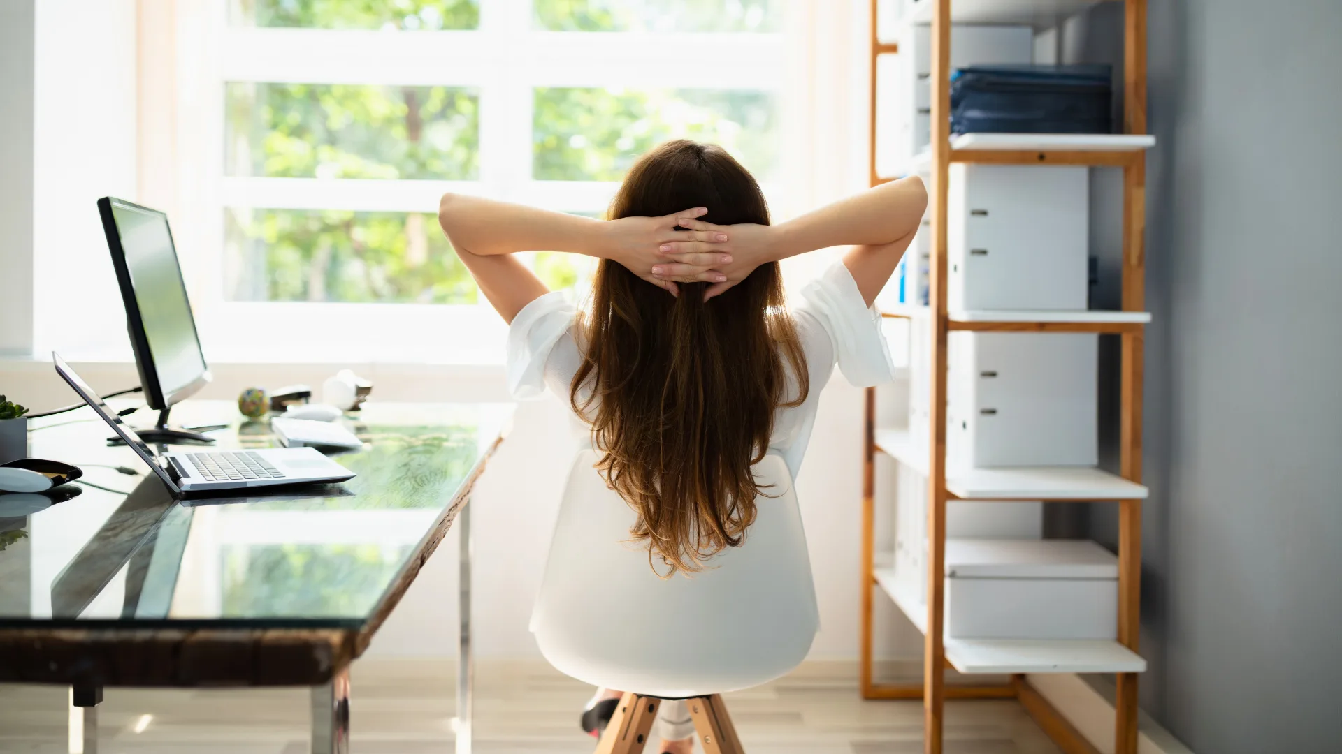 mulher-reflexiva-solidao-home-office-trabalho-remoto-impacto-emocional.jpg Mulher com a mão na cabeça, expressão reflexiva de solidão após um dia de home office, simbolizando o impacto emocional do trabalho remoto, Solidão