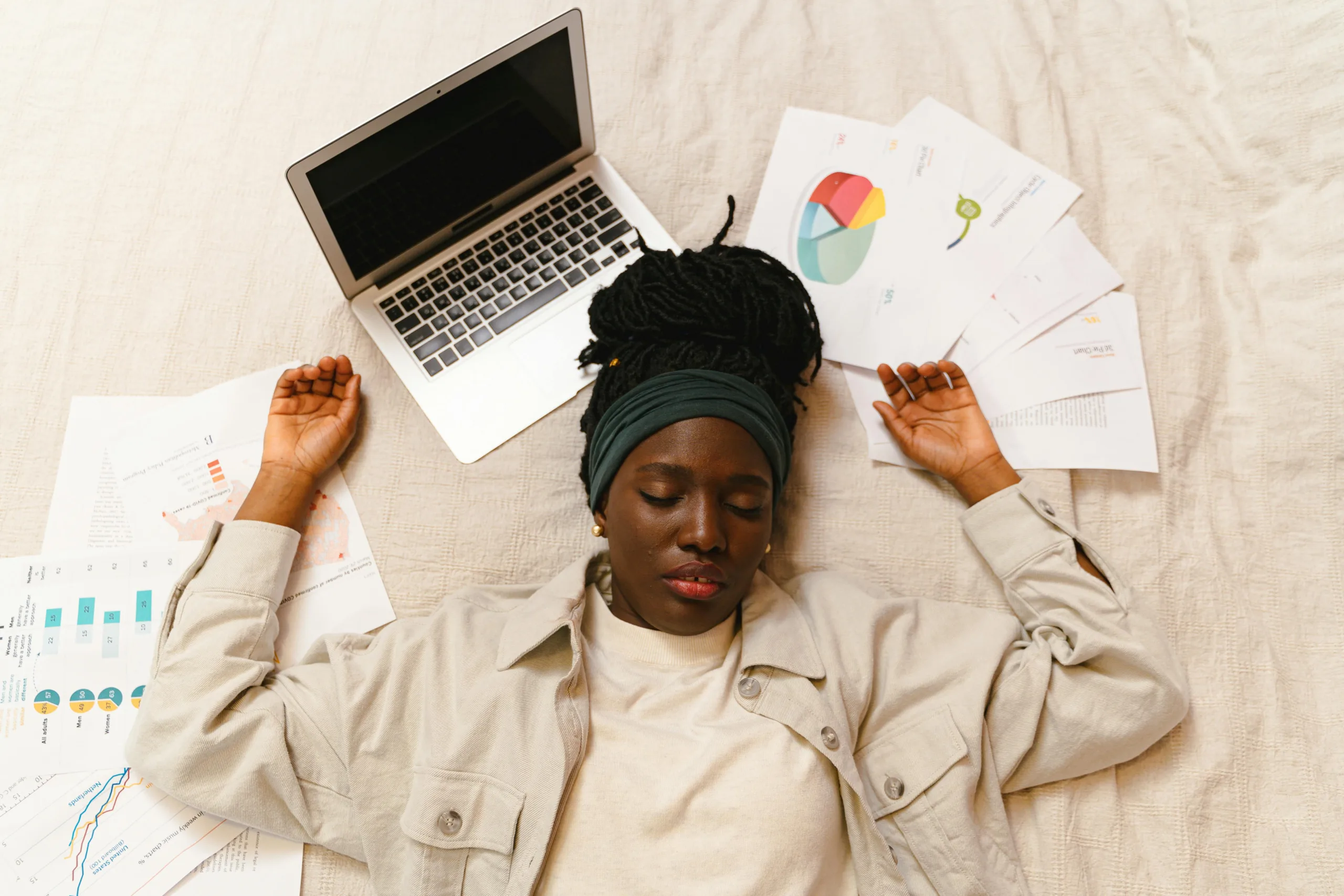 Sono no expediente? Conheça 7 receitas simples e rápidas para turbinar sua energia no home office 1 Tired woman with closed eyes lying by laptop and papers after work.