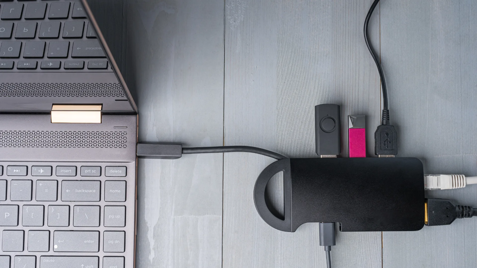 Gadgets para produtividade: 5 aliados que realmente fazem diferença no seu home office 6 Hub USB conectado ao notebook, com vários dispositivos plugados.