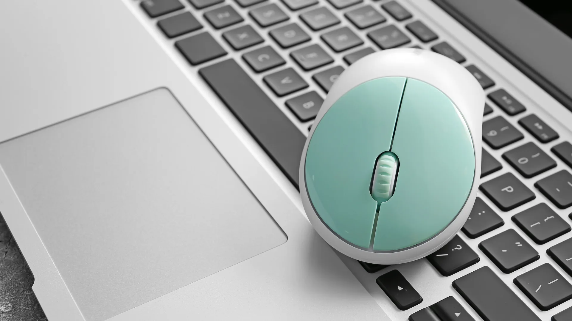 Mouse branco com detalhes azul em cima de notebook